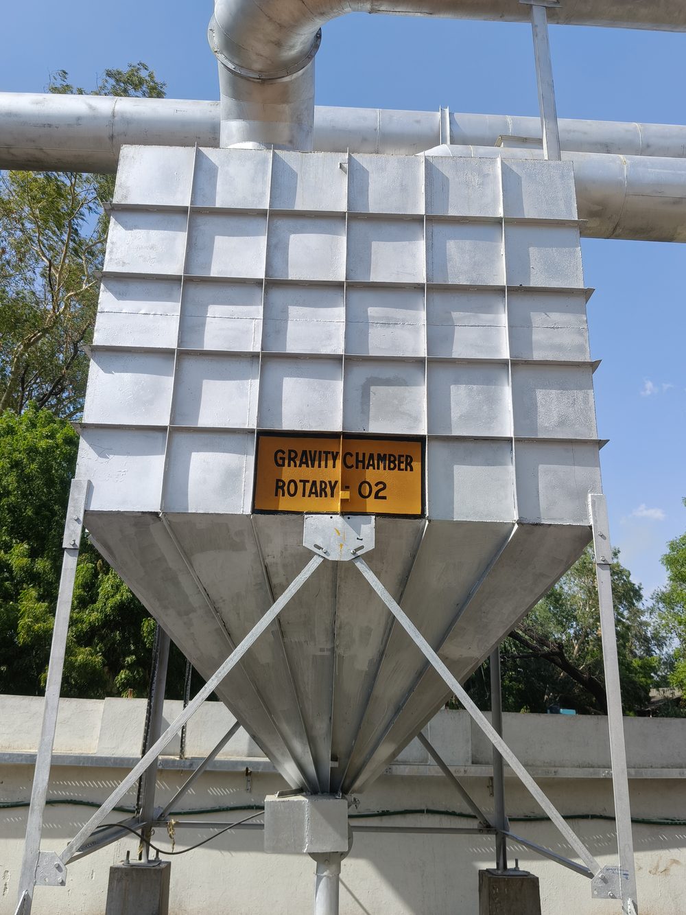 Gravity chamber ahead of the bag filtration line